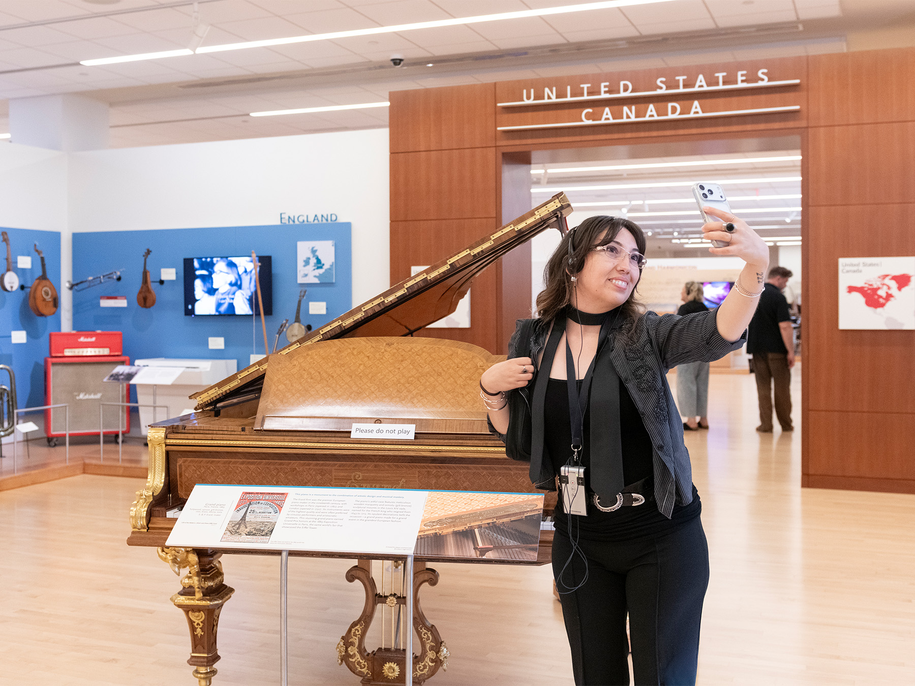 A guest takes a selfie in front of the Erard grand piano in the Europe Gallery